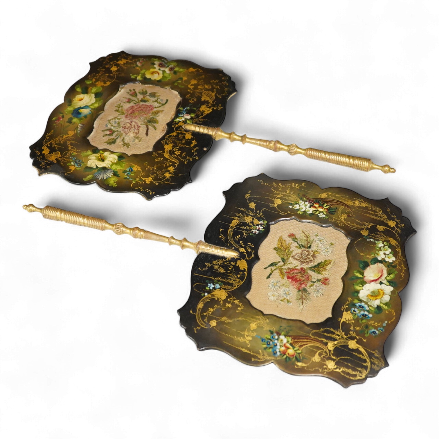 A pair of early Victorian papier maché hand screens, each with embroidered with cross stitched flowers, 41cm in length